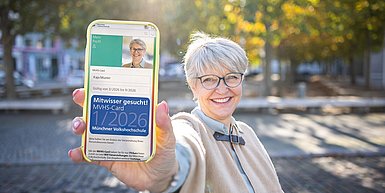 ältere Frau mit MVHS-Card 1/2026 auf dem Smartphone